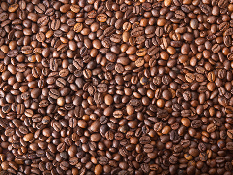 Numerous coffee beans which have been scattered all over the sur