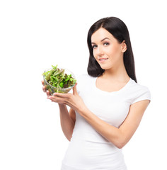 Healthy girl with a bowl of green salad isolated on white