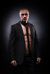 Fototapeta premium Strong, fit and sporty stripper man over black background