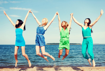 Fototapeta na wymiar girls jumping on the beach