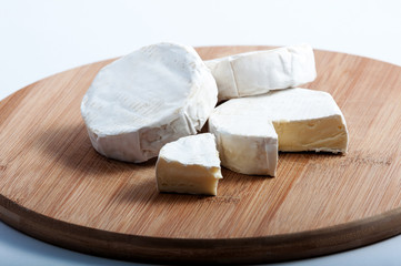 a few pieces of cheese on a wooden board
