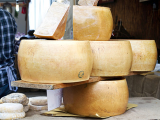 large blocks of italian form of parmesan cheese exposed on a tab