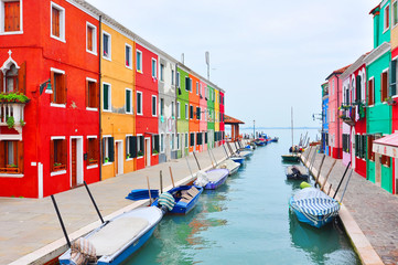 Burano island canal, colorful houses church. Italy.