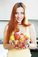 cheerful houswife holding peaches