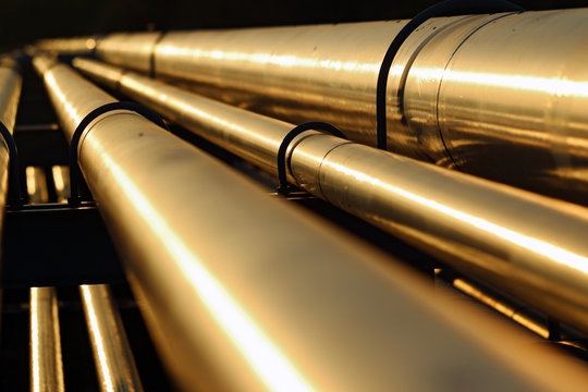 golden steel pipeline during sunset