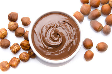 A cup of chocolate hazelnut spread with hazelnuts