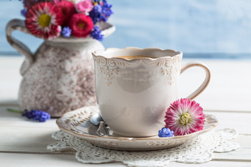 Spring flowers and coffee on old table