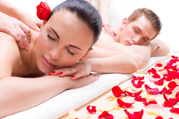 Couple lying  in a spa salon enjoying back massage.