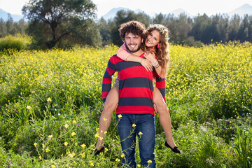 Young man giving his girlfriend a piggy back.