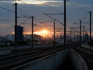 Fototapeta na wymiar Railway at sunset with city in background