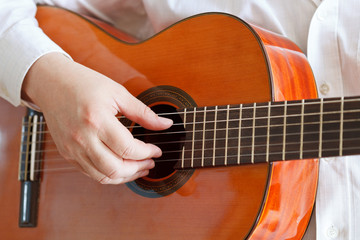 man plays on classical modern guitar