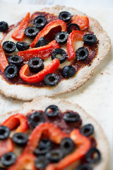 Close-up of mini pizzas with red bell pepper and olives