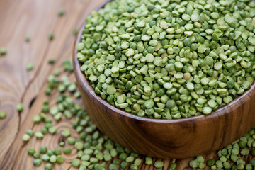 Close-up of dried green peas in a wooden bowl, studio shot