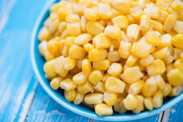 Close-up of sweet corn kernels, blue wooden surface, studio shot