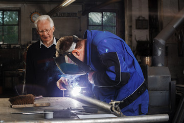 Blacksmith And Senior In The Workshop