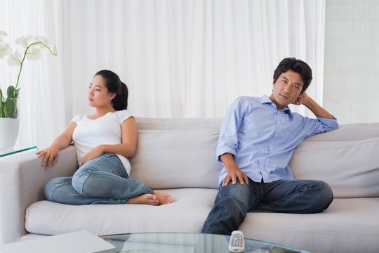 Couple not talking after a dispute on the sofa