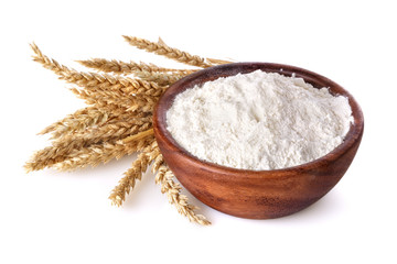 flour with wheat in a wooden bowl on a white background