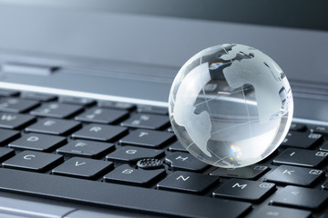 Glass globe on laptop keyboard
