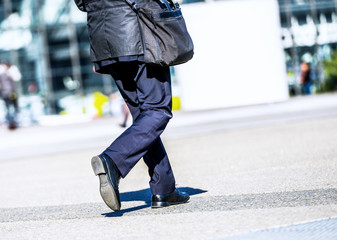 Business traveler man walking with suitcase in the street