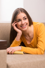 beautiful girl lying on brown sofa.