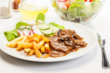 Pork chop with sauce, mushrooms and chips