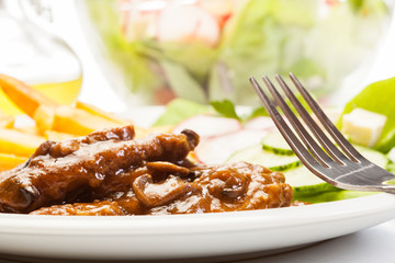 Pork chop with sauce, mushrooms and chips