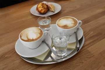 Glasses of coffee with water on tray