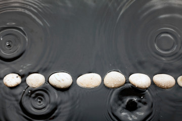 White stones in the water in the rain