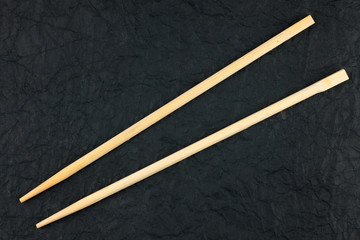 Chopsticks lay on a black napkin