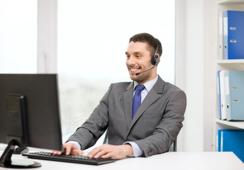 helpline operator with headphones and computer
