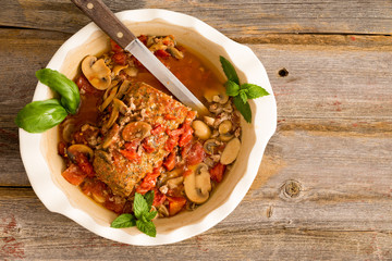 Sliced meatloaf in a casserole on a rustic table with copy space
