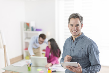  businessman using a digital tablet and standing in front of his