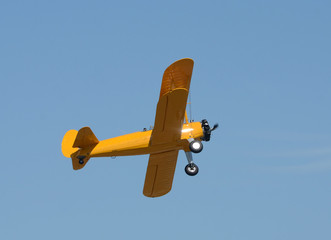 Old yellow biplane in flight