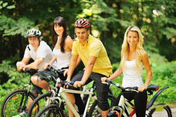 Naklejka premium Group of attractive happy people on bicycles in the countryside