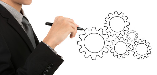 Businessman hand drawing gear to success concept