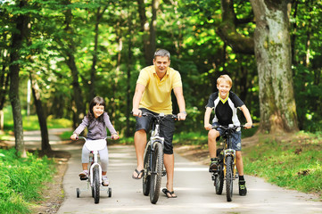 Happy family on a bicycles in the countryside