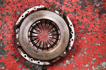 an old worn out vehicle clutch on a red background