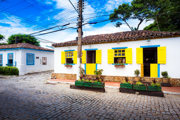 Fototapeta na wymiar Small white houses with colorful window shutters in Buzios, Braz