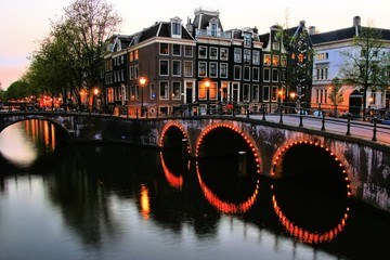 Famous canals of Amsterdam lit up at dusk, Netherlands © Jenifoto