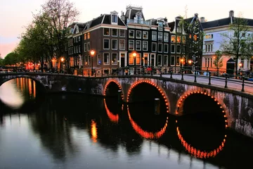 Zelfklevend Fotobehang Famous canals of Amsterdam lit up at dusk, Netherlands © Jenifoto