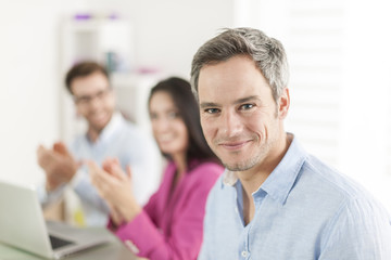 businessman congratulated by colleagues