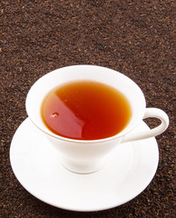 A cup of tea on dried and processed tea leaves