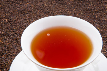 A cup of tea on dried and processed tea leaves