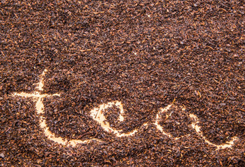 Written TEA word on dried tea leaves
