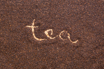 Written TEA word on dried tea leaves