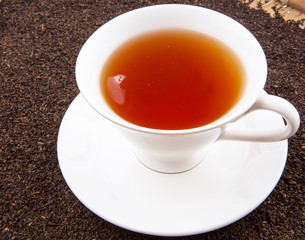 A cup of tea on dried and processed tea leaves