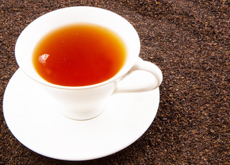 A cup of tea on dried and processed tea leaves