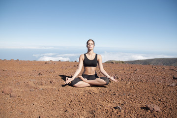 Fototapeta na wymiar Young woman meditating in the nature