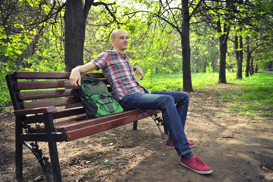 Guy Sits On A Bench In Park