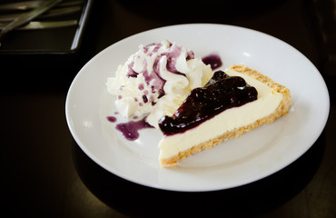 Blue blueberry cheesecake with whipped cream.
